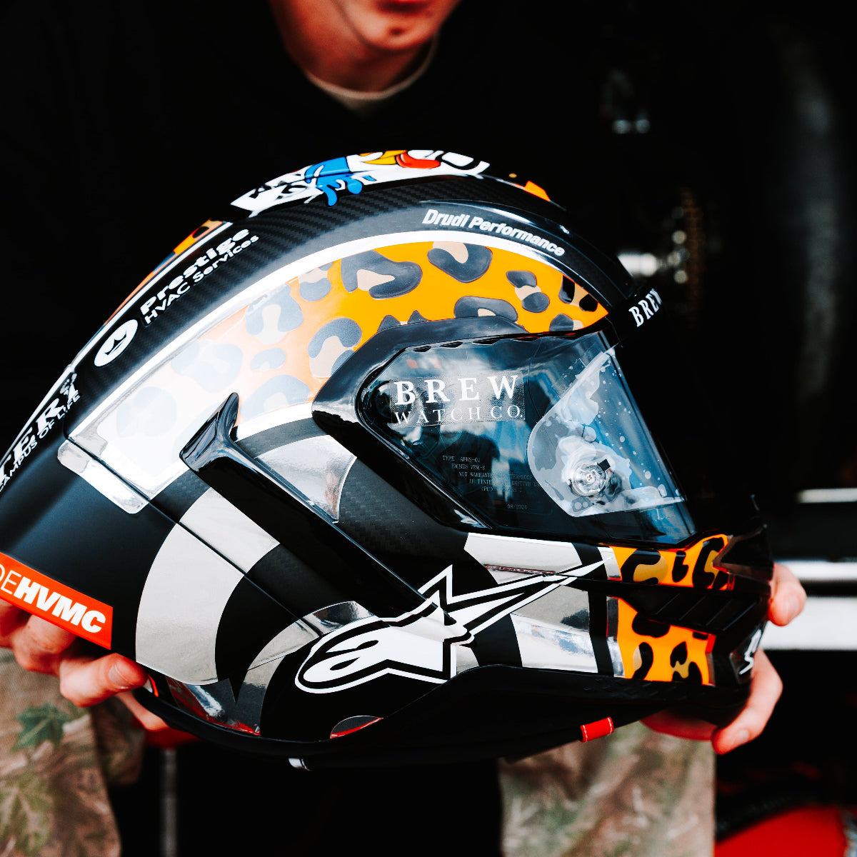 Person holding a colorful motorcycle helmet with visible branding