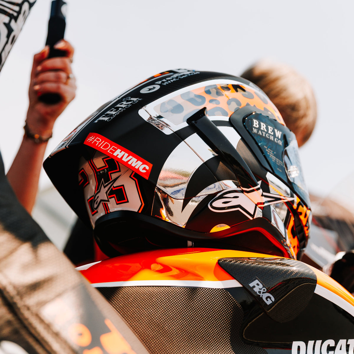 Person wearing a helmet with branding on a motorcycle, with a blurred background
